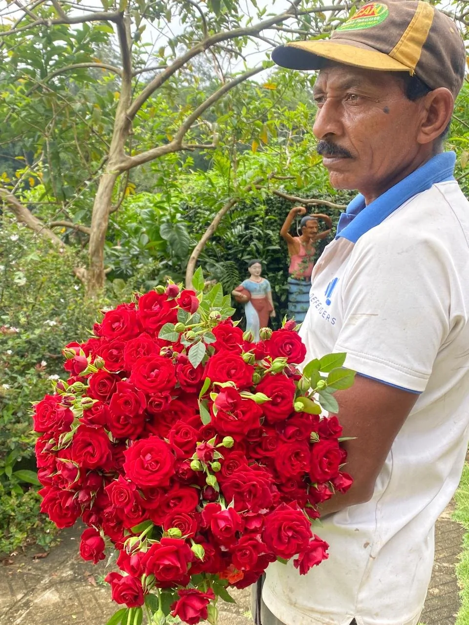Estate grower holding a large bouquet of red roses outdoors