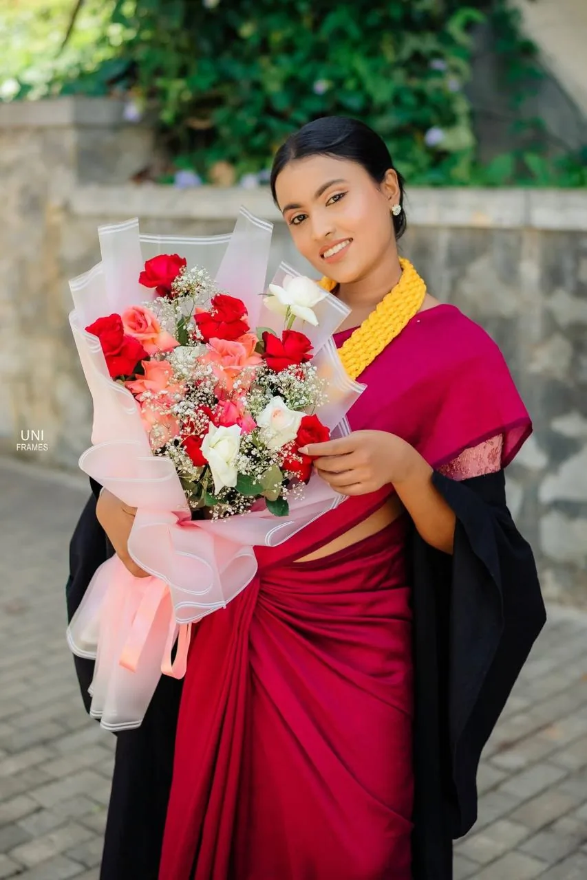 Graduate holding a mixed rose bouquet