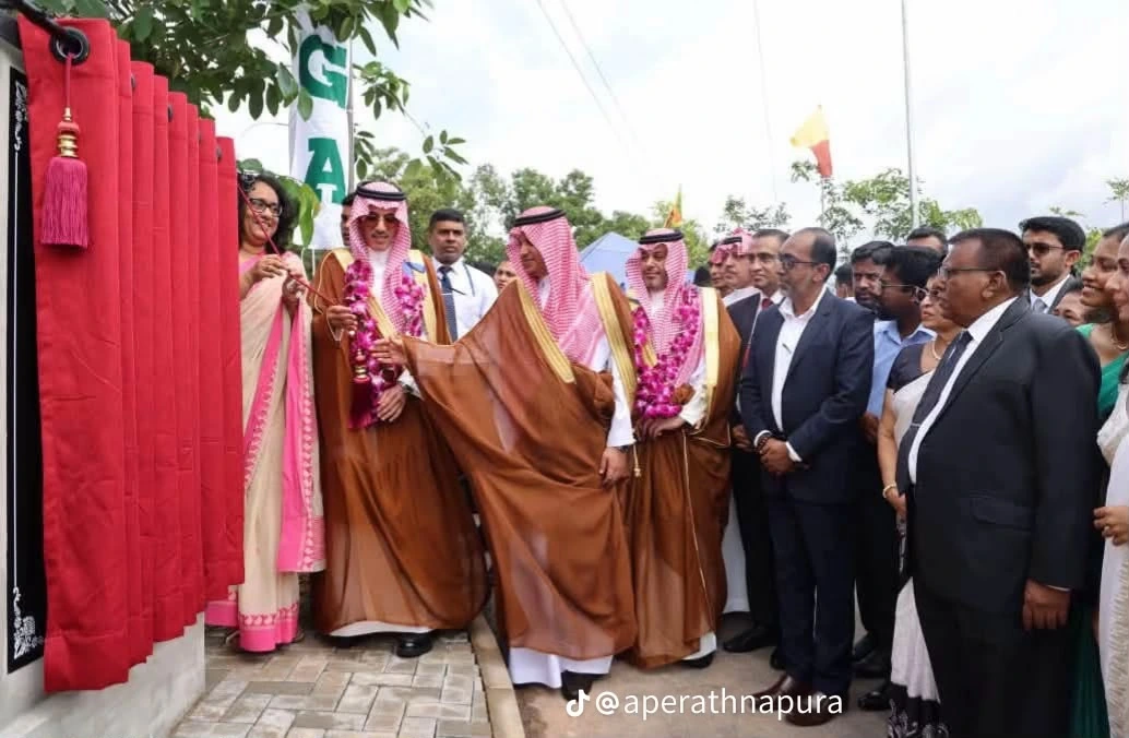 Guests unveiling a commemorative plaque, guests wearing bright pink floral garlands